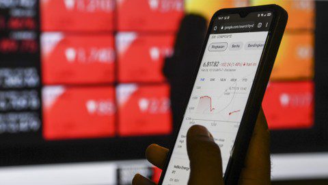 Warga melihat layar pergerakan saham pada gawainya di Jakarta, Kamis (24/2/2022). Foto: ANTARA FOTO